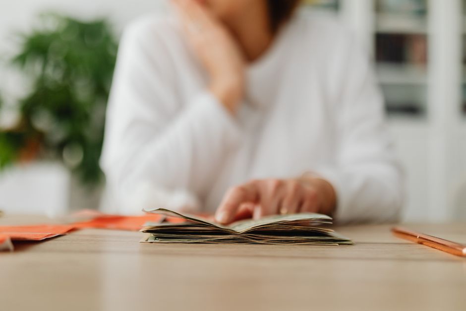 Monedas apiladas junto a una libreta con anotaciones